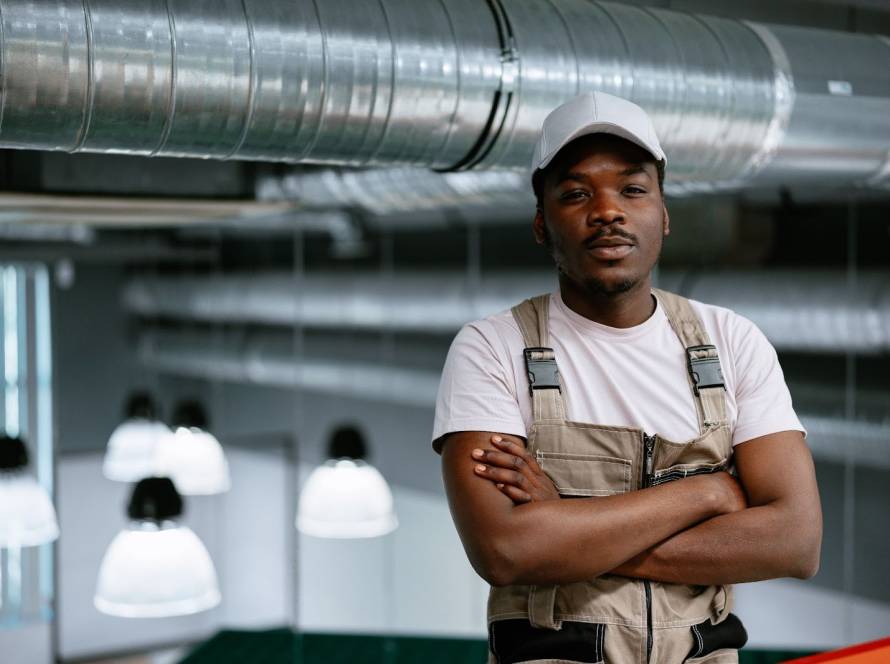 A young worker poses after servicing an interior AC duct.